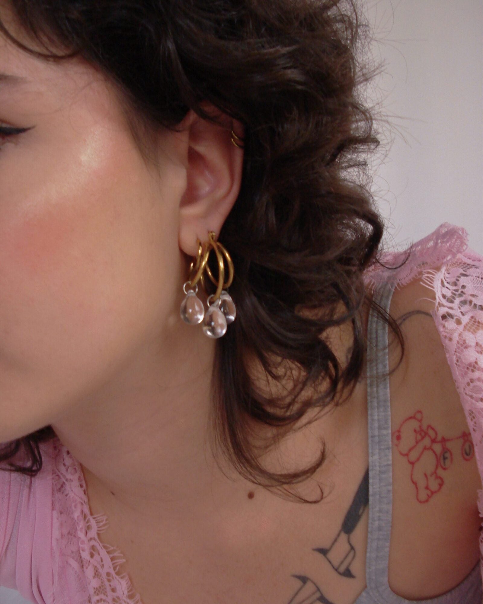 Mono boucle d’oreilles en acier inoxydable composée d'une créole doré, et de perles en verre tchèque transparentes