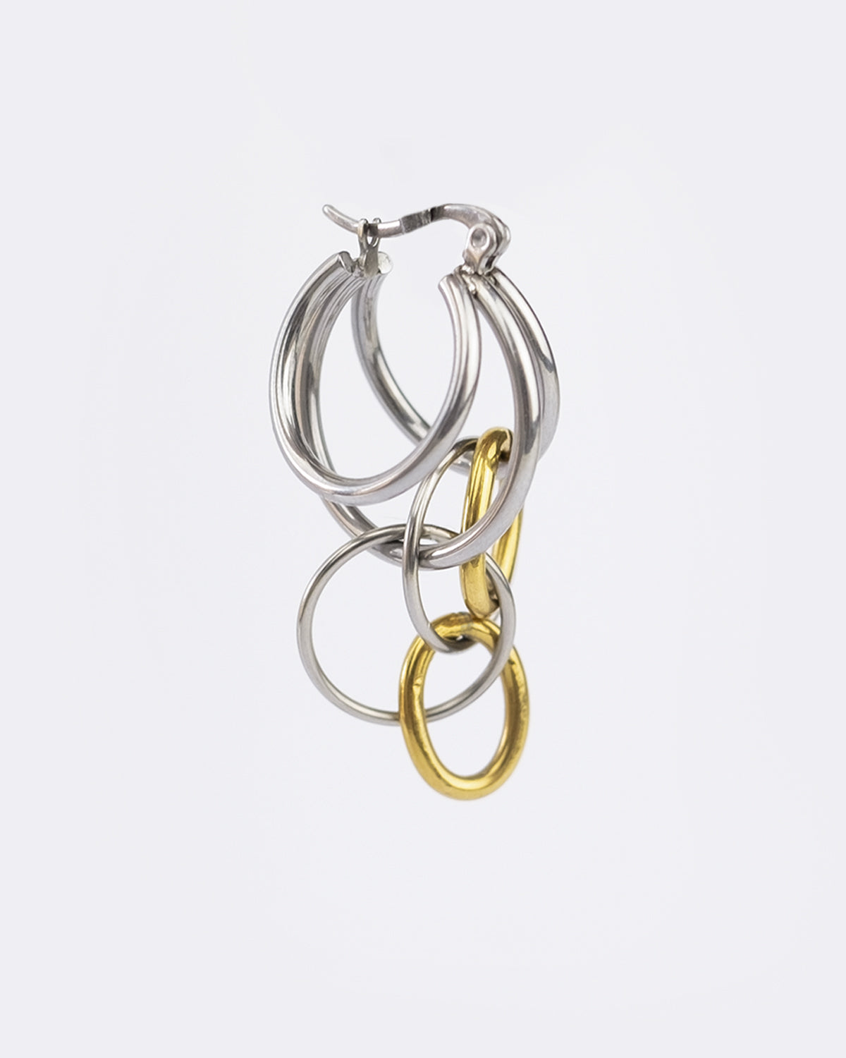 Mono boucle d’oreilles en acier inoxydable composée d'une créole argenté et de plusieurs anneaux doré et argenté de tailles différentes.