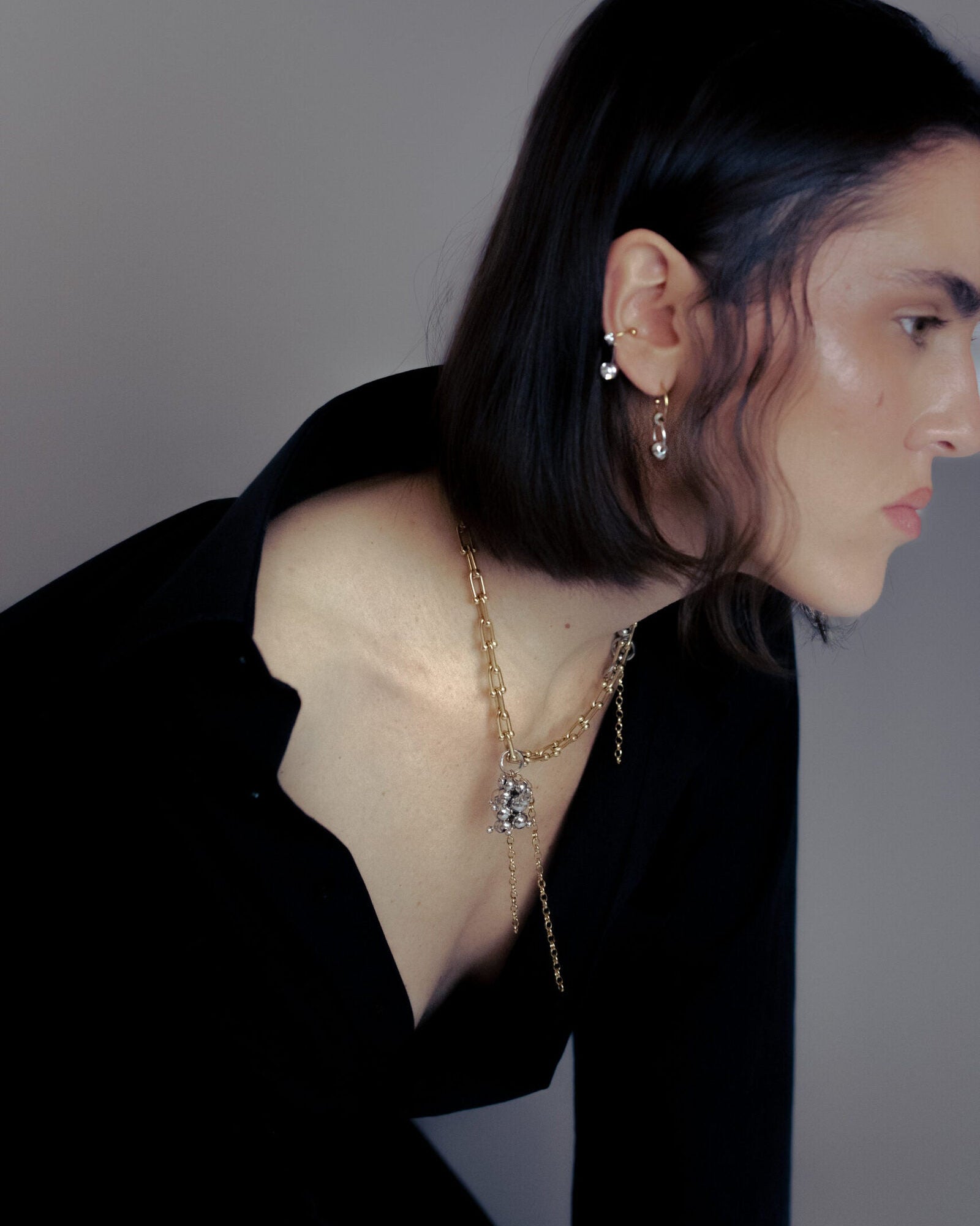 Collier en acier inoxydable . Il s'agit d'un collier composé d'une chaine dorée, agrémentée d'anneaux argenté et d'une grappe de perle argentée