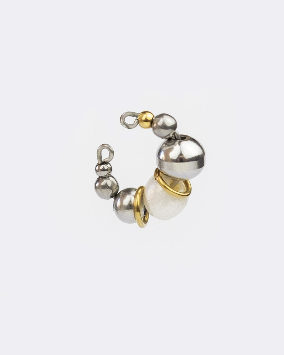 Earcuff en acier inoxydable. Il s’agit d’un faux piercing pour oreille non perçée qui se positionne au niveau du conch ou du lobe suivant la largeur de l’oreille. Il est composé d’un anneau argenté, de perles argentées, d'une perle de culture d'eau douce et d'anneaux dorés interposés