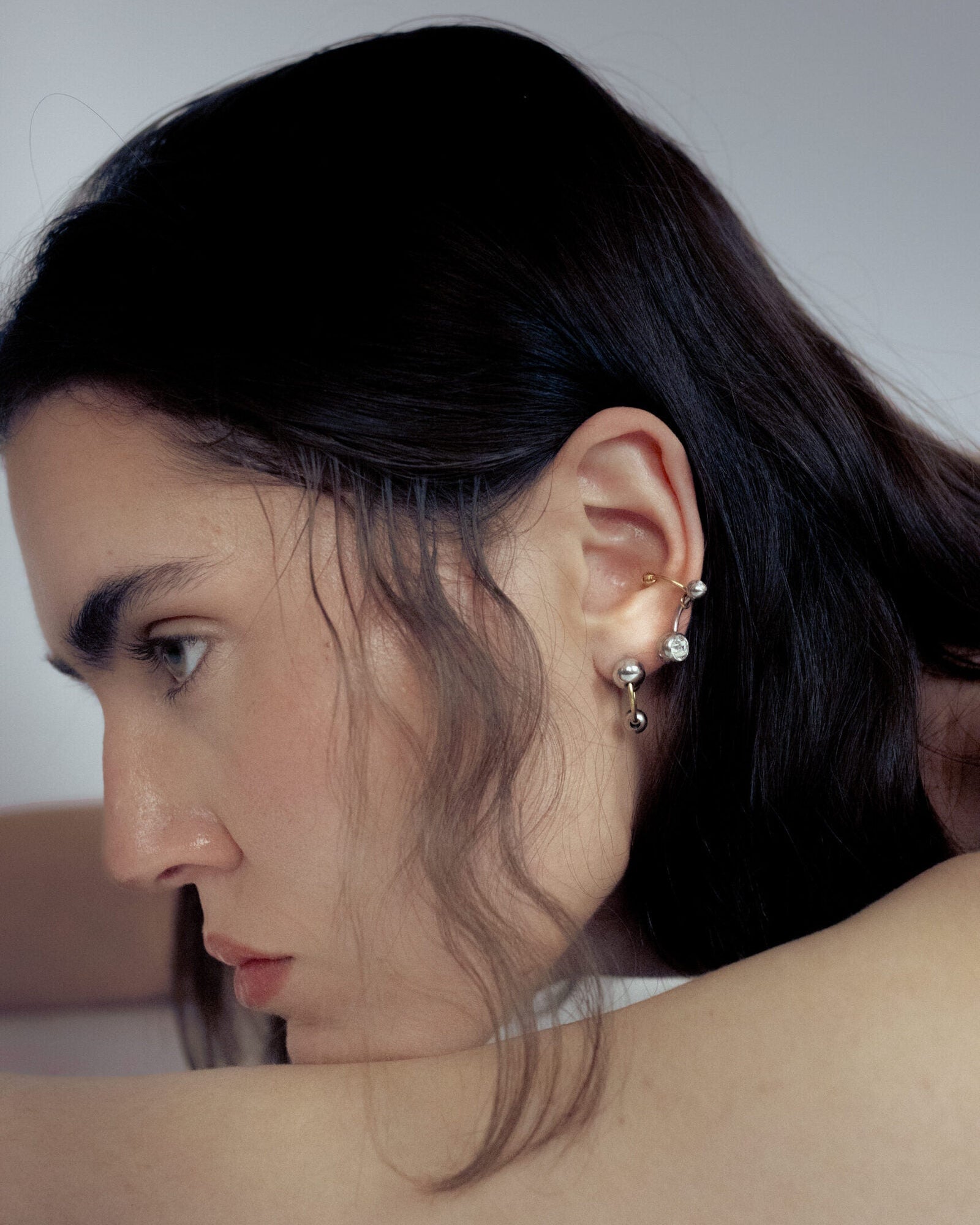 Mono boucle d’oreilles en acier inoxydable composée d’une demi-créole dorée et de deux perles argentées de différentes tailles
