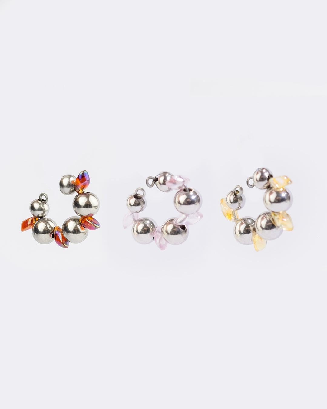 Earcuff en acier inoxydable. Il s’agit d’un faux piercing pour oreille non perçée qui se positionne au niveau du conch ou du lobe suivant la largeur de l’oreille. Il est composé d’un anneau argenté, avec des perles en verre de trois variantes de couleur et argentées.