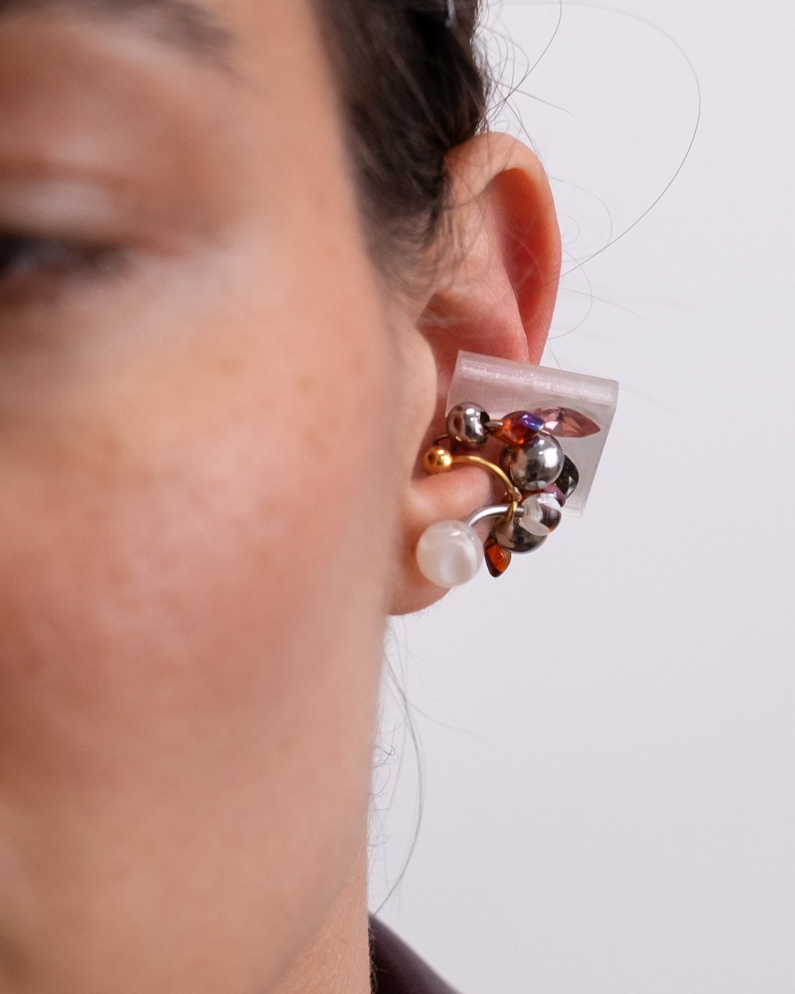 Earcuff en acier inoxydable. Il s’agit d’un faux piercing pour oreille non perçée qui se positionne au niveau du conch ou du lobe suivant la largeur de l’oreille. Il est composé d’un anneau argenté, avec des perles en verre de trois variantes de couleur et argentées.