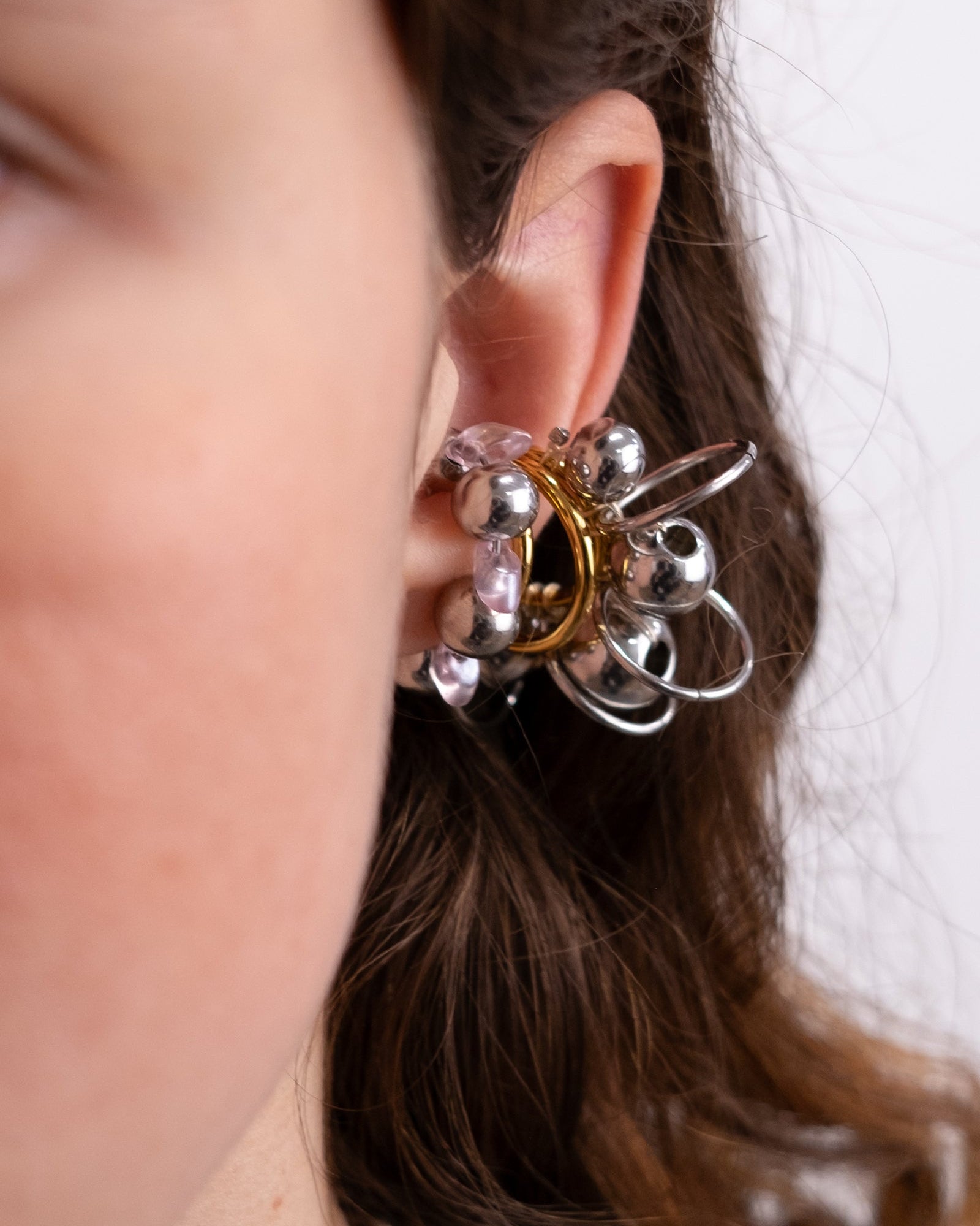 Earcuff en acier inoxydable. Il s’agit d’un faux piercing pour oreille non perçée qui se positionne au niveau du conch ou du lobe suivant la largeur de l’oreille. Il est composé d’un anneau argenté, avec des perles en verre de trois variantes de couleur et argentées.