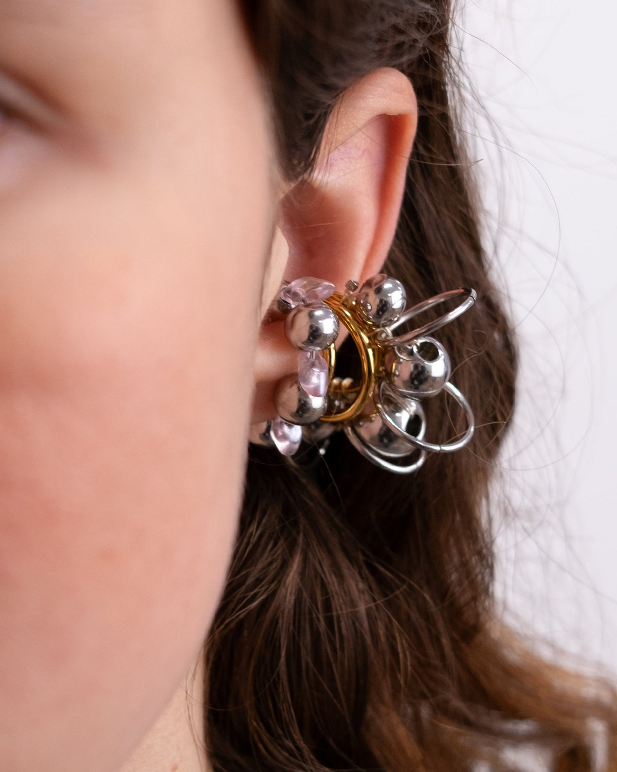 Earcuff en acier inoxydable porté en set composé d'un anneau argenté avec des perles en verre couleur light pink et argentées