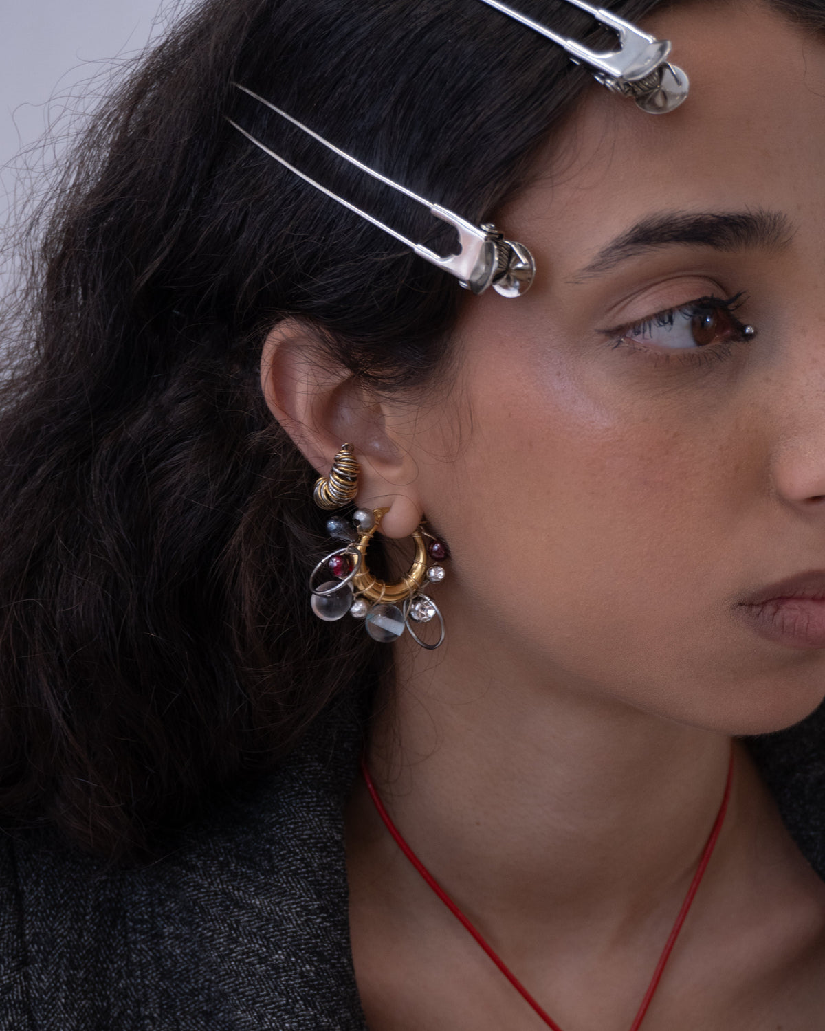 Mono boucle d’oreilles en acier inoxydable porté composée d’une créole dorée, de différentes perles tressées en verre hématite cristal et anneaux argentés