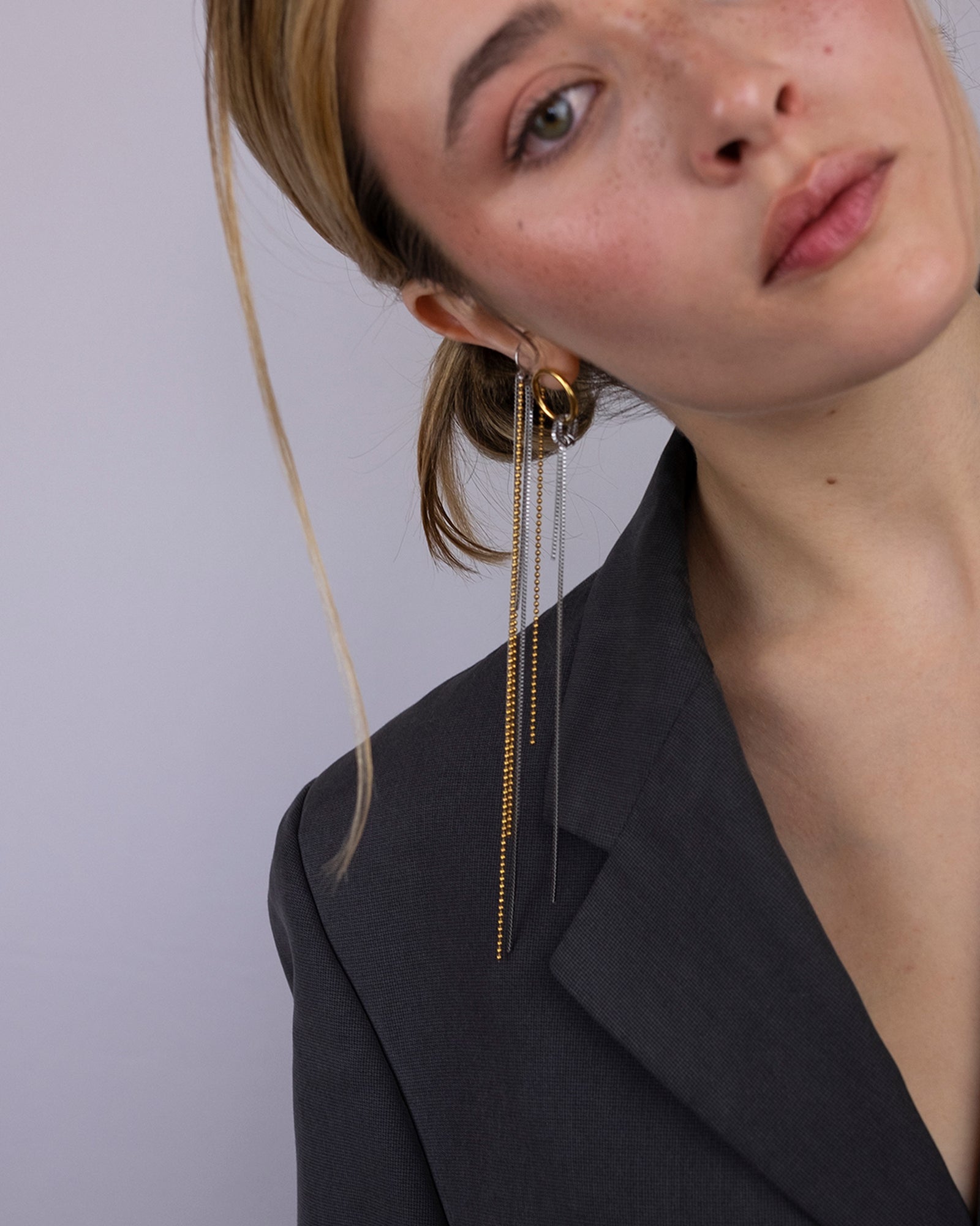 Earcuff en acier inoxydable. Il est composé d'un anneau argenté et d'une multitude de chaines doré et argenté de différentes longueurs.