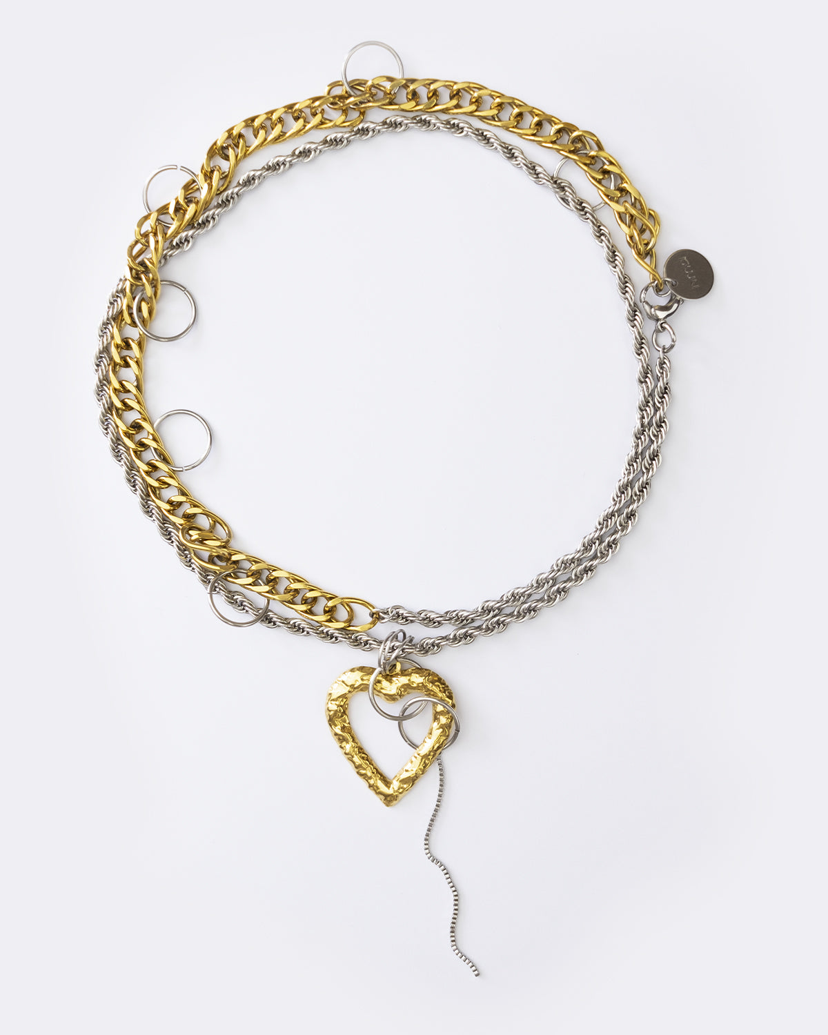 Collier en acier inoxydable avec une chaine doré et d'une chaine argenté qui peut se porter en version longue et en choker, avec un pendentif coeur martelé
