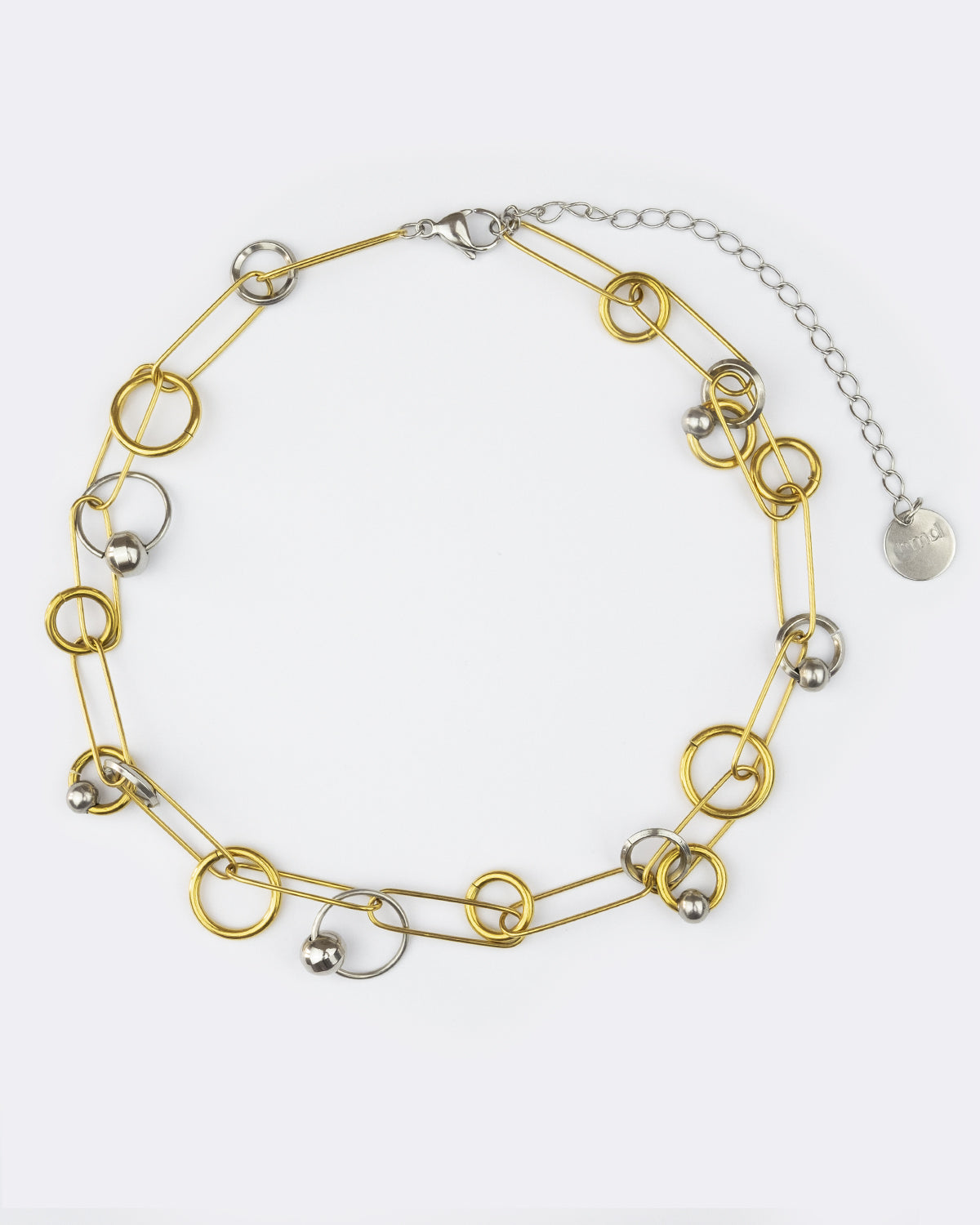 Collier en acier inoxydable. Il s'agit d'un collier composé d'une chaine doré entrelacée de plusieurs anneaux doré et argenté de différentes tailles et de différentes épaisseur