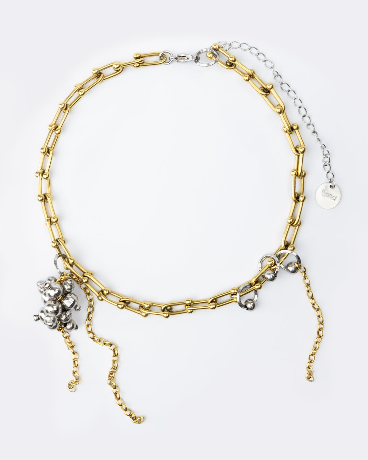 Collier en acier inoxydable . Il s'agit d'un collier composé d'une chaine dorée, agrémentée d'anneaux argenté et d'une grappe de perle argentée