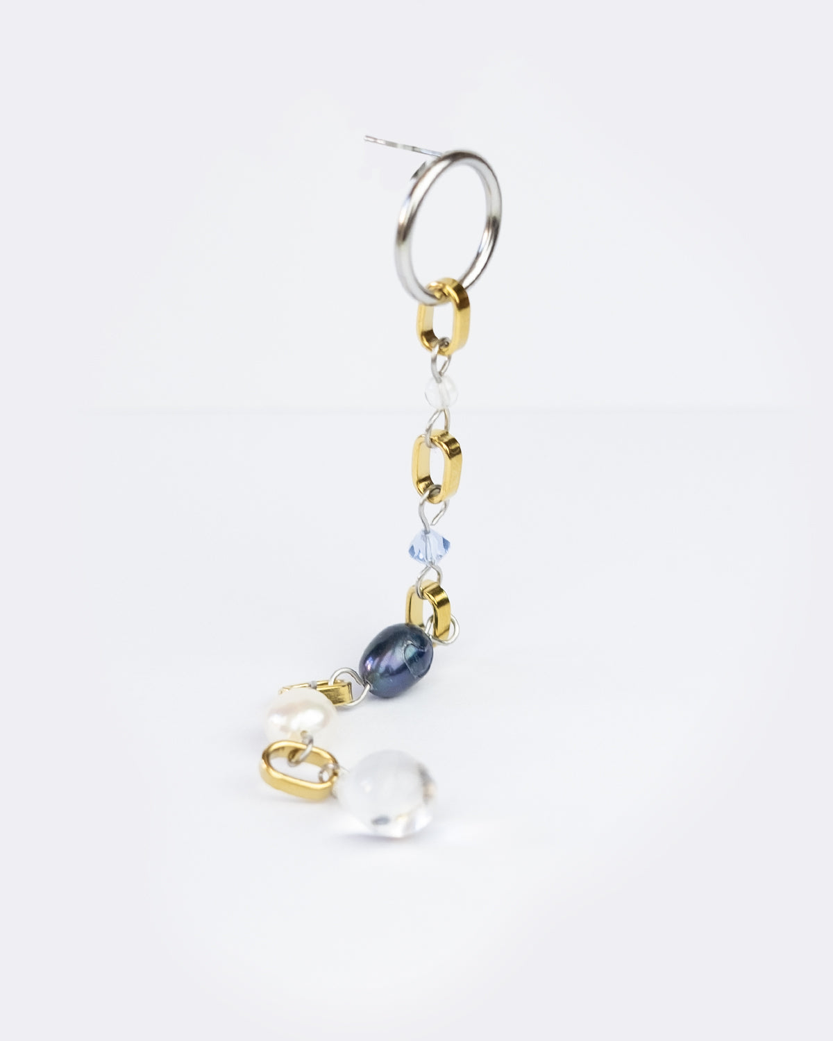 Mono boucle d’oreilles en acier inoxydable composée d'une puce d'oreilles argentée, de multiples anneaux dorés interposés entre des perles variées en verre, perle de culture, et cristal