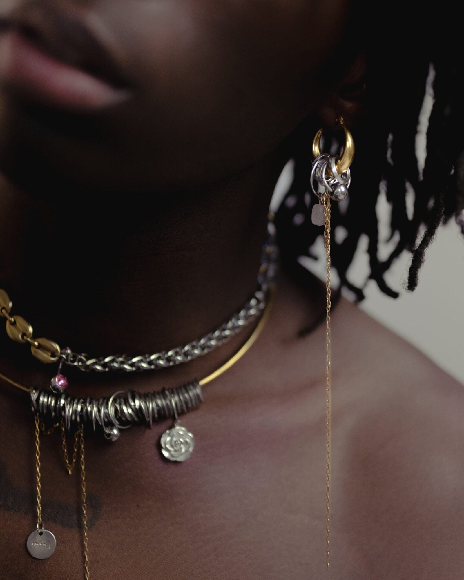 Mono boucle d’oreilles en acier inoxydable composée d’une créole dorée, d'anneaux argentés, d'une pierre en quartz rose et d'une chaine pendante doré