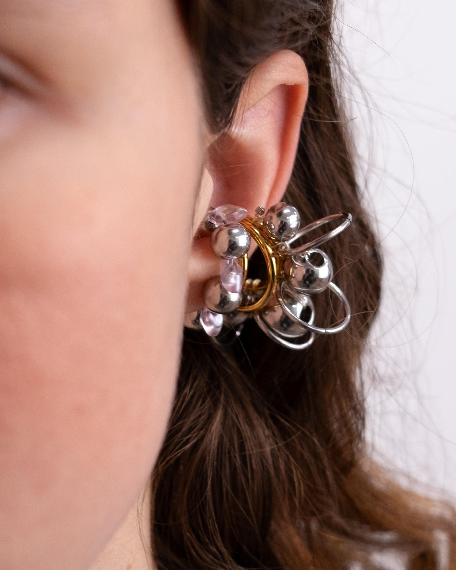 Earcuff en acier inoxydable. Il s’agit d’un faux piercing pour oreille non perçée qui se positionne au niveau du conch ou du lobe suivant la largeur de l’oreille. Il est composé d’un anneau argenté, avec des perles en verre de trois variantes de couleur et argentées.