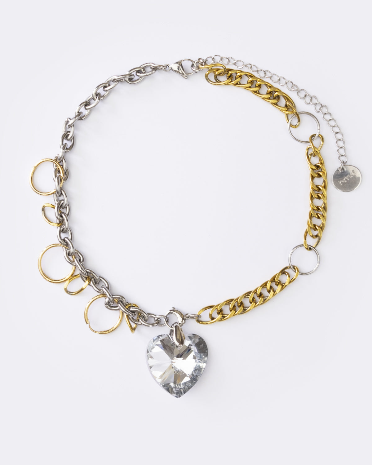 Collier en acier inoxydable composé d'une chaîne dorée et argentée entrelacée de plusieurs anneaux, avec un pendentif cœur en cristal