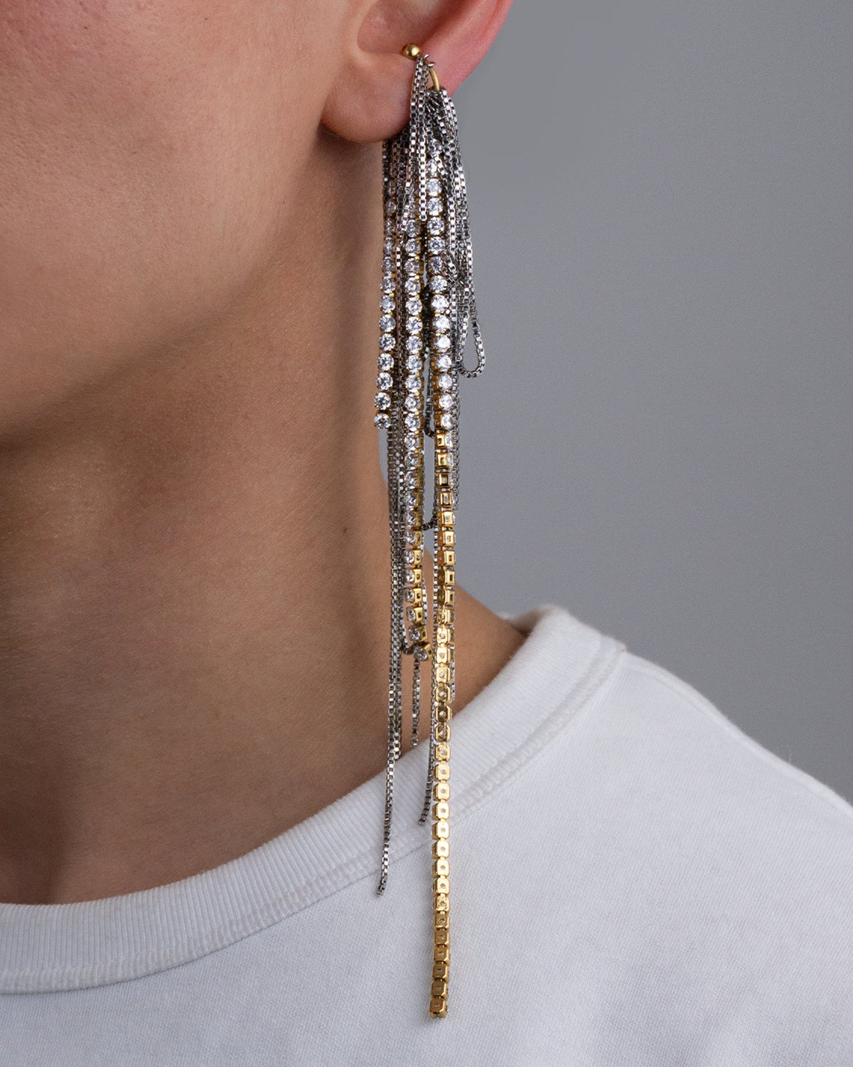 Earcuff en acier inoxydable porte composé d’un anneau doré et d’une multitude de chaînes argentées de différentes longueurs et de chaînes en strass.
