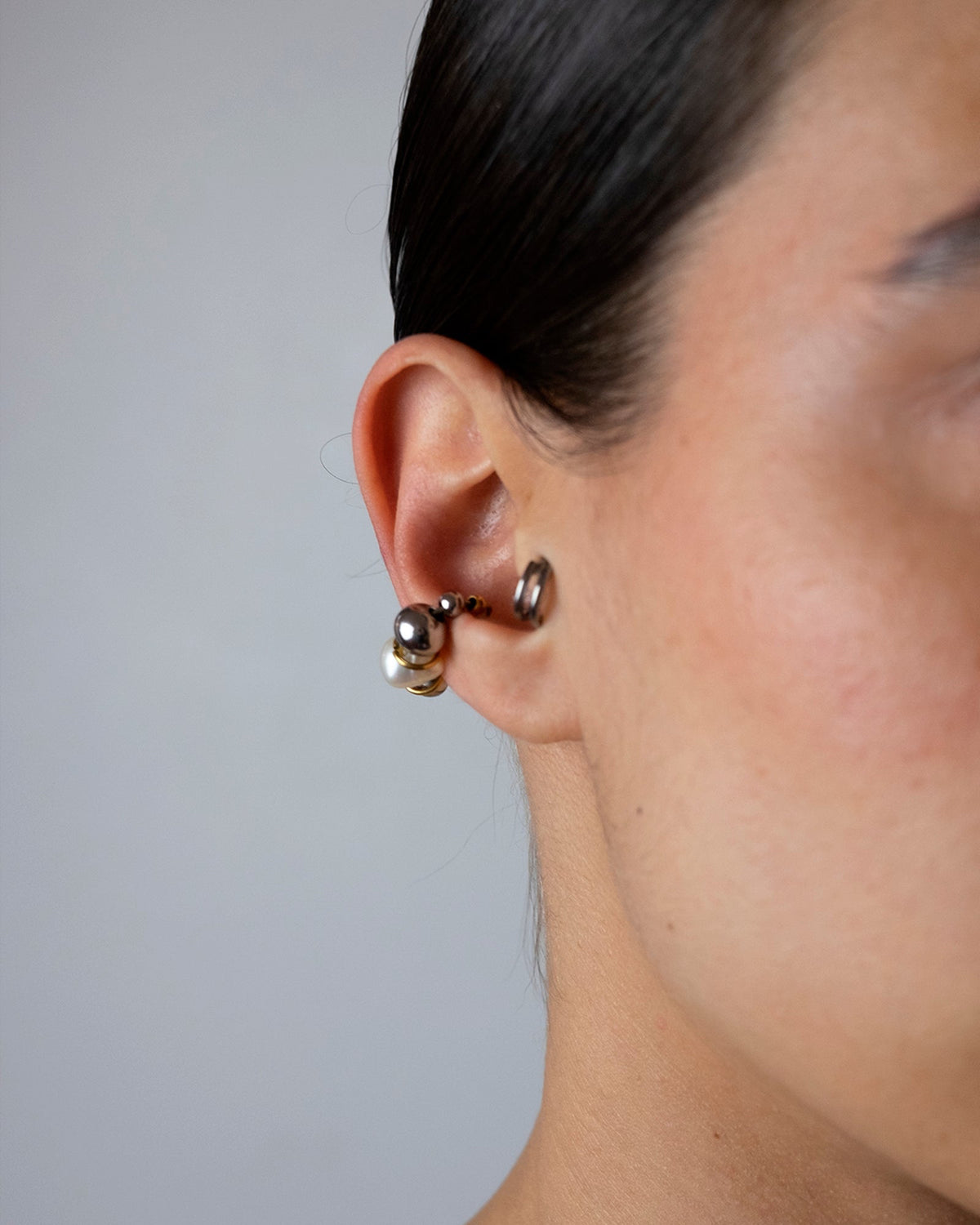 Earcuff en acier inoxydable porté composé d'un anneau argenté de perles argentées d'une perle de culture d'eau douce et d'anneaux dorés interposés