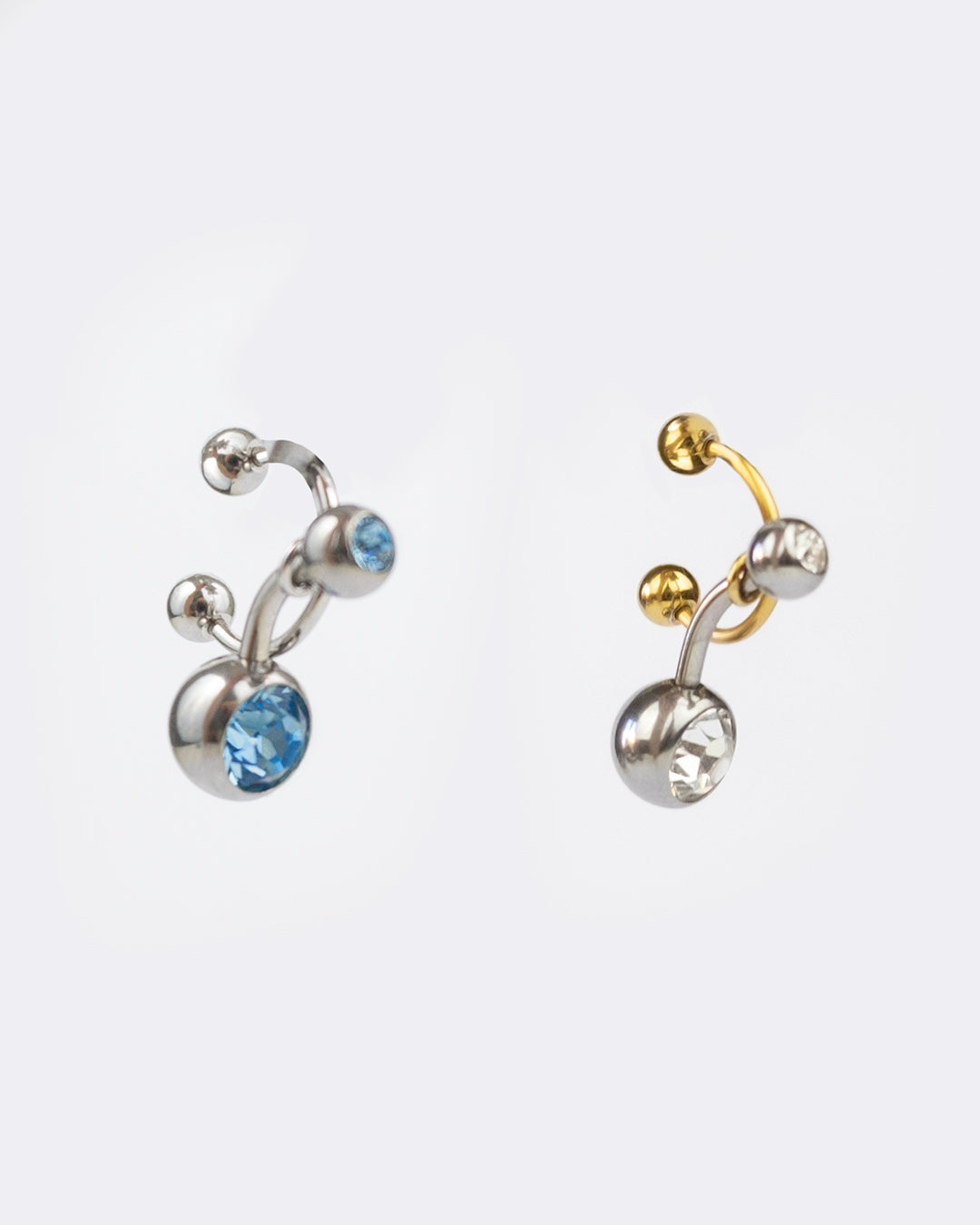 Gamme Earcuff en acier inoxydable qui se positionne au niveau du conch ou du lobe suivant la largeur de l’oreille composé d’un anneau doré ou argenté et d’un piercing avec un zirconium cristal blanc ou bleu
