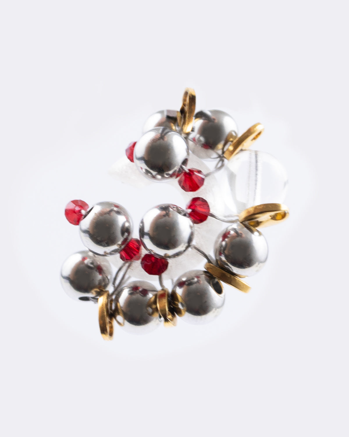 Earcuff Jelly Duo Rouge porté en plastique biosourcé composé d'une multitude de perles argentées de grains de café dorés et de perles en verre colorées rouges tressés sur une base transparente