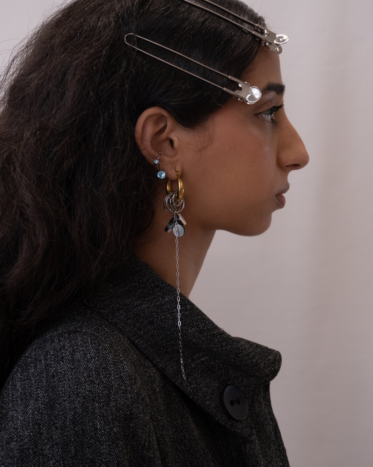 Mono-boucle d’oreille en acier inoxydable porté composée d’une créole dorée d’anneaux argentés de perles en nacre et d’une chaîne pendante argentée