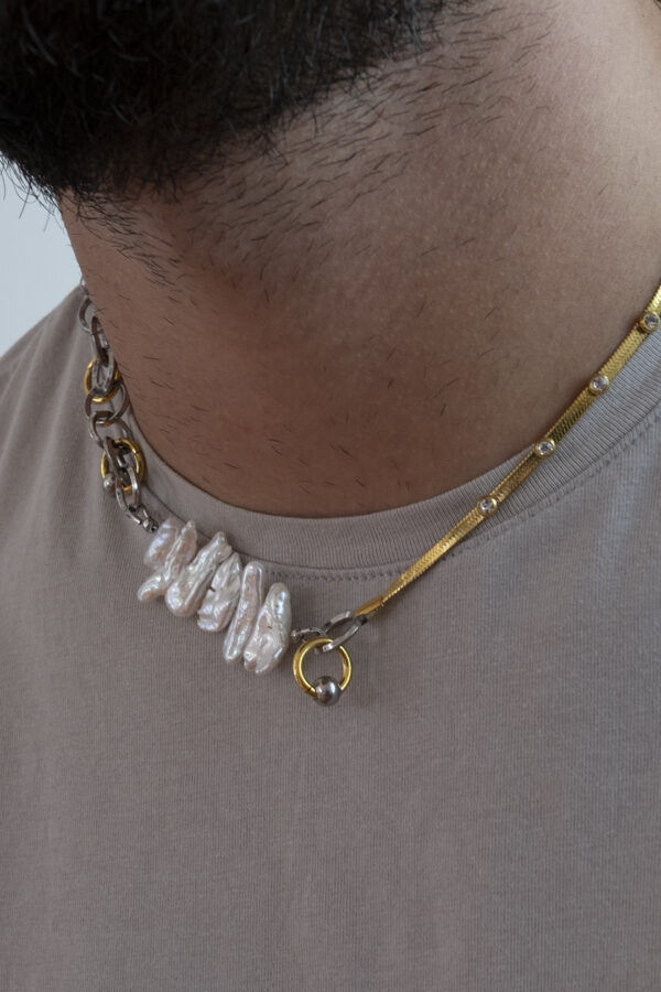 Collier en acier inoxydable. Il s'agit d'un collier composé d'une chaine argenté, de perles de culture d'eau douce Biwa et d'une chaine doré incrustée d'oxyde de zirconium